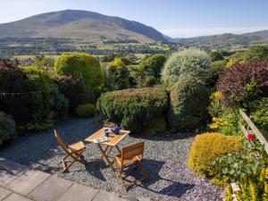 a garden with a table and chairs and a mountain at 2 Bed in Threlkeld SZ082 in Threlkeld