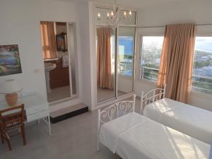 a bedroom with two beds and a bathroom with a balcony at Mille ou une nuit in Tunis