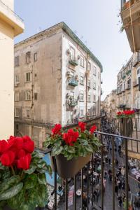 a balcony with red roses on a city street at Pignasuite in Naples