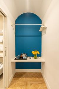 Zimmer mit blauer Wand und Regal in der Unterkunft Pignasuite in Neapel