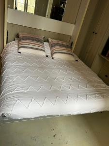 uma grande cama branca com duas almofadas em Maison stylée avec jardin caché, Vincennes em Vincennes