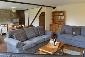 - un salon avec deux canapés bleus et une table dans l'établissement Rose Cottage Wheddon Cross, à Minehead