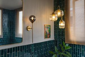 a bathroom with green tiled walls and a mirror at 清迈古城柚子别墅塔佩门里 in Chiang Mai +33 photos