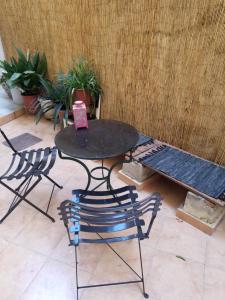 una mesa y dos sillas y un banco en un patio en This is the beginning, en Atenas