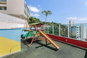 a playground on the roof of a building next to a pool at Piscina com Vista MAR próximo à UFSC #PANTA03 in Florianópolis