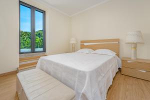 ein weißes Schlafzimmer mit einem weißen Bett und einem Fenster in der Unterkunft Casa da Quebrada in Santana