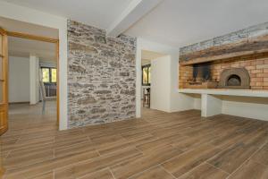 ein Wohnzimmer mit einer Steinmauer und einem Kamin in der Unterkunft Casa da Quebrada in Santana
