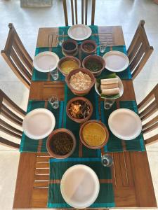 una mesa con platos y tazones de comida. en Villa Heshni Colombo, en Sri Jayewardenepura Kotte