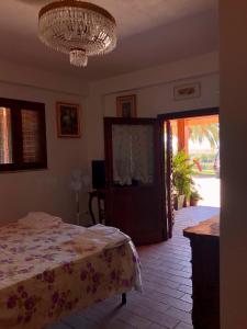 a bedroom with a bed and a chandelier at APPARTAMENTO FONTEBELLA in Montemarciano