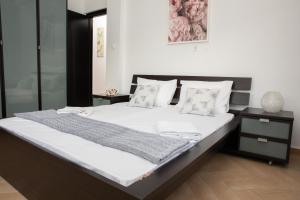 1 dormitorio con 1 cama grande con sábanas y almohadas blancas en Emerald Heaven, en Panteli