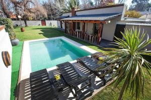 a swimming pool with chairs and a house at Casa Wineland Logde West 4Pax - by Inside in Ciudad Lujan de Cuyo +5 photos