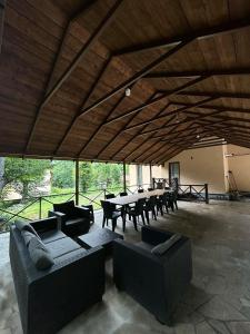 a patio with couches and tables and chairs at Dilijan Dream House! 3 Bedroom Amazing Villa in National Park! in Dilijan