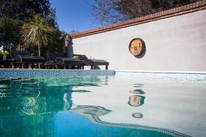 a swimming pool with a clock on the side of a building at Casa Wineland Logde West 4Pax - by Inside in Ciudad Lujan de Cuyo