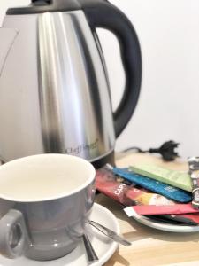 - une tasse de café sur une table à côté d'une théière dans l'établissement Hôtel Ô9 marches, à Rillieux-la-Pape