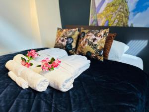 een stapel handdoeken met bloemen op een bed bij Gilly's Gallery in Breda