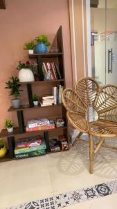 a room with a chair and a book shelf at OSTELO Mumbai Airport Hostel in Mumbai