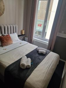 a bedroom with a bed with towels and a window at Nonne Blanche in Ostend