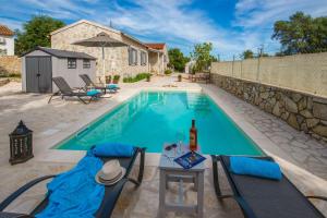 a swimming pool with a table and chairs in front of a house at Villa Labovitsa in Vlachopoulátika