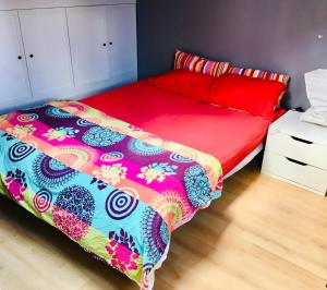 - une chambre avec un lit et une couette colorée dans l'établissement Maison stylée avec jardin caché, Vincennes, à Vincennes