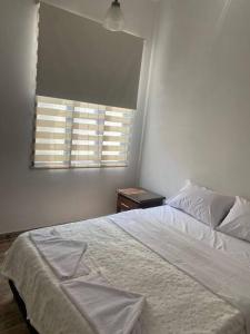 a bedroom with a white bed and a window at Casa Aparicio in Buga