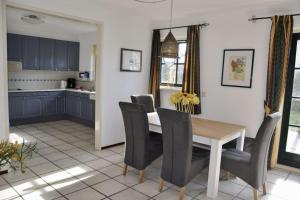a kitchen and dining room with a table and chairs at Buitenplaats 144 in Callantsoog