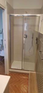 La salle de bains est pourvue d'une douche avec une porte en verre. dans l'établissement B&B Ninfa, à Caserte