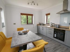 uma cozinha com uma mesa e algumas cadeiras amarelas em Sea View em Carmarthen