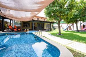 uma piscina com um guarda-chuva sobre ela em Amazing family house in Oaxtepec Pool & Hot tub em Oaxtepec