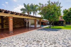 uma casa de tijolos com um pátio e uma árvore em Amazing family house in Oaxtepec Pool & Hot tub em Oaxtepec