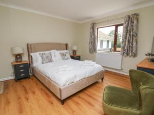 um quarto com uma cama, uma cadeira e uma janela em Sea View em Carmarthen