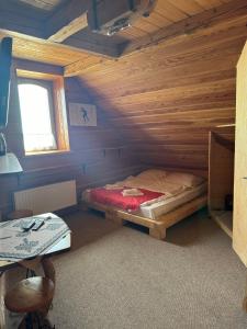 a bedroom with a bed in a wooden room at Krynicka Koliba na Jaworzynie Krynickiej in Krynica Zdrój
