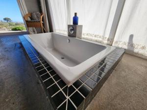 a white bath tub in a room with a window at Mustique-Beachfront bliss in St. Helena Bay +66 photos