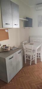 - une cuisine avec une table et une table et des chaises blanches dans l'établissement B&B Ninfa, à Caserte