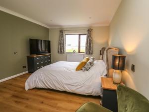 a bedroom with a bed and a desk and a television at The Oaks in Carmarthen