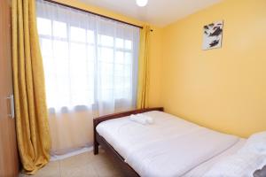 1 dormitorio con cama y ventana en The Perfect New Nest en Nairobi