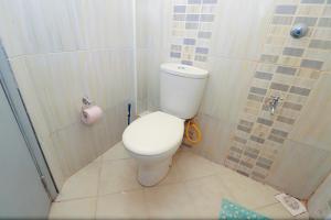 a small bathroom with a toilet in a shower at The Perfect New Nest in Nairobi