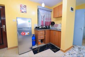 a kitchen with a refrigerator and a window at The Perfect New Nest in Nairobi