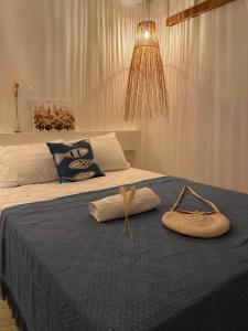 Un dormitorio con una cama con un edredón azul y un sombrero. en Vila Oceano en Barra de São Miguel