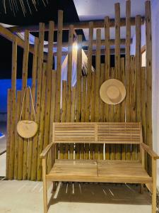 un banco de madera sentado frente a una valla de madera en Vila Oceano en Barra de São Miguel