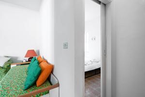 - une chambre avec un lit doté d'oreillers vert et orange dans l'établissement Villa Tiffany T58 by Rentbeat, à Rosa Marina