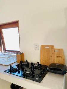 cocina con fogones y ventana en Vila Oceano en Barra de São Miguel