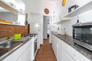 La cuisine blanche est équipée d'un évier et d'un réfrigérateur. dans l'établissement Villa Tiffany T58 by Rentbeat, à Rosa Marina 13 autres photos