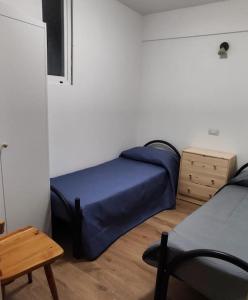 Schlafzimmer mit einem blauen Bett und einem Tisch in der Unterkunft Casa vacanze Margherita in Laterza