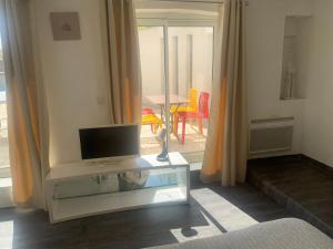 a living room with a tv and a glass table at Bon séjour au Soleil in Marseille