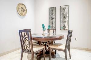 a dining room table with two chairs and a clock at Lujoso departamento en Leon in León