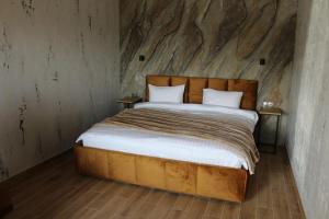 a bed in a room with a stone wall at Готель-ресторан "Колиба" in Brody