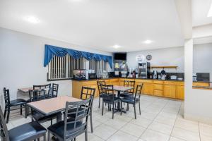 a dining room with tables and chairs and a kitchen at Super 8 by Wyndham Richfield UT in Richfield