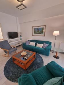 ein Wohnzimmer mit einem Sofa und einem Couchtisch in der Unterkunft Park view apartment near Panormou in Athen