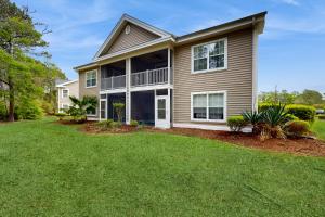 ein Haus mit Rasen davor in der Unterkunft True Blue Unit 37-C in Pawleys Island