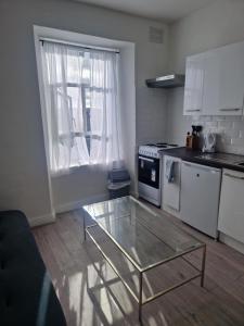 eine Küche mit einem Couchtisch aus Glas vor einem Fenster in der Unterkunft Inviting 1-Bed Apartment in Cork in Cork